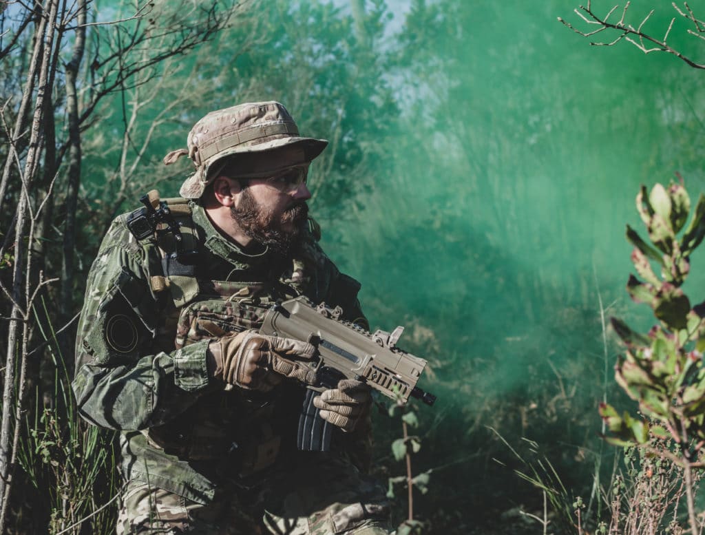 joueur d'airsoft avec sa réplique d'uzi en forêt 