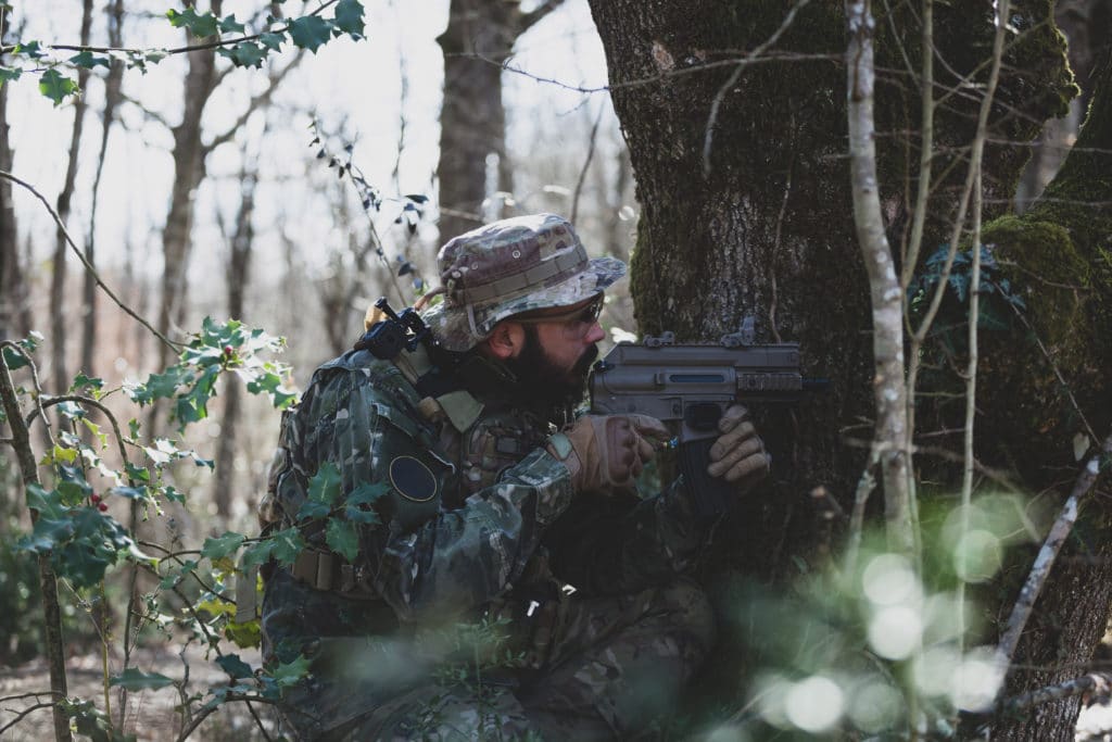 joueur d'airsoft en milieux extérieur avec sa réplique de fn2000 