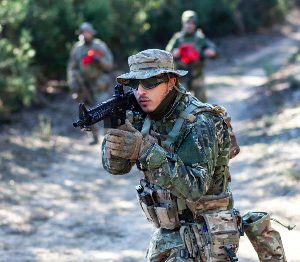 joueur d'airsoft avec sa réplique de fusil d'assaut en pleine action
